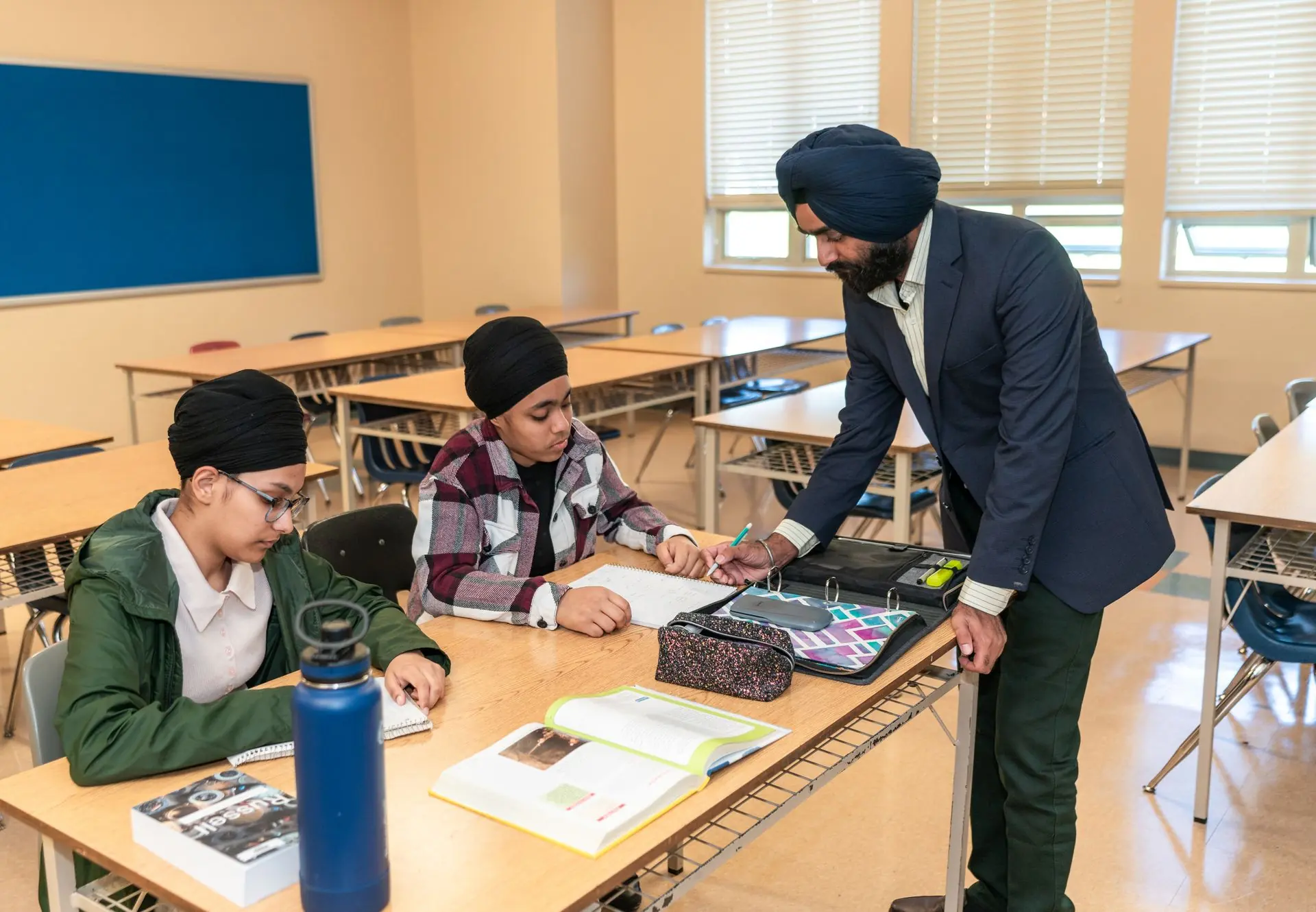 A teacher guiding pupils working at their desks during a classroom activity