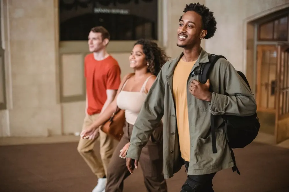 Students with backpacks walking through a college corridor