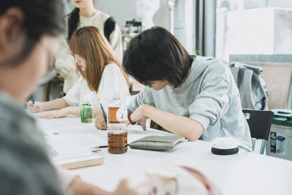 Students drawing together at an art studio worktable