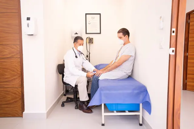 A doctor examining a seated patient in a clinic room
