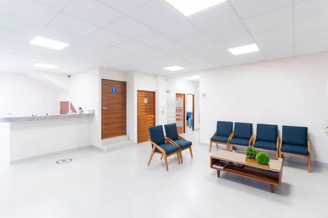 A bright clinic waiting area with blue chairs