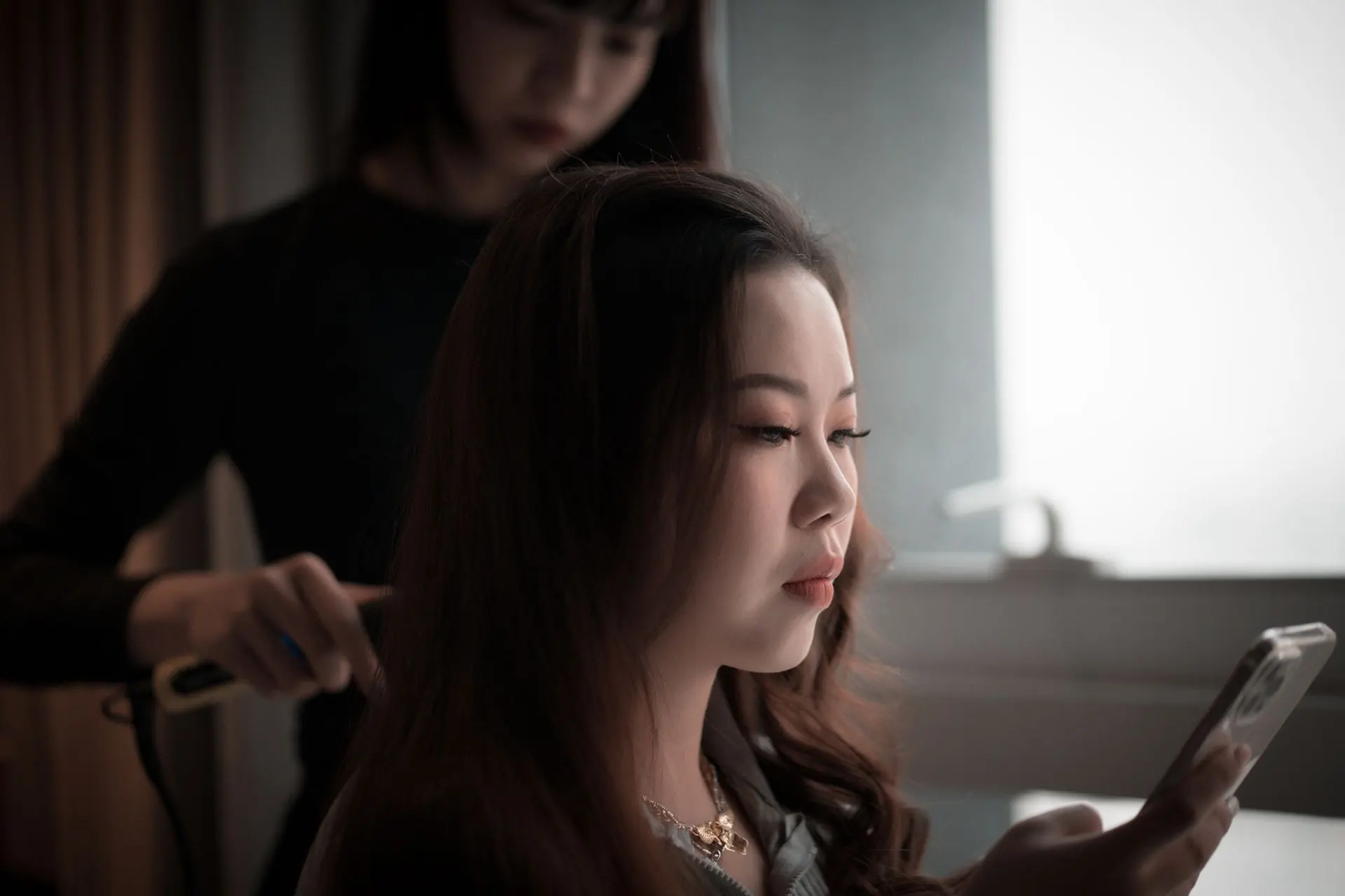 A stylist carefully working on a client’s hair