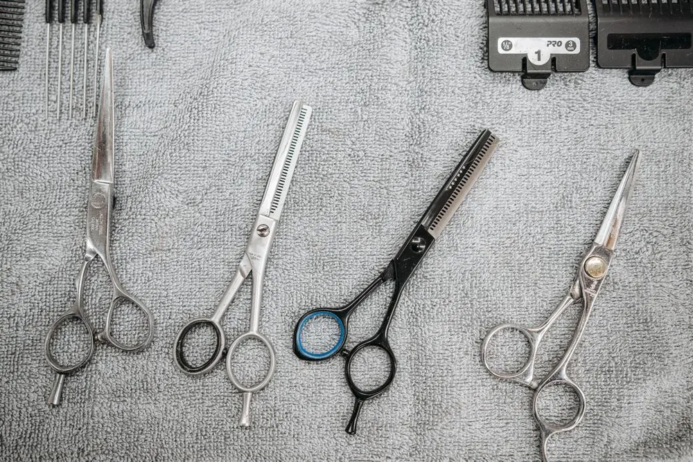 Scissors, combs and grooming tools arranged on a towel