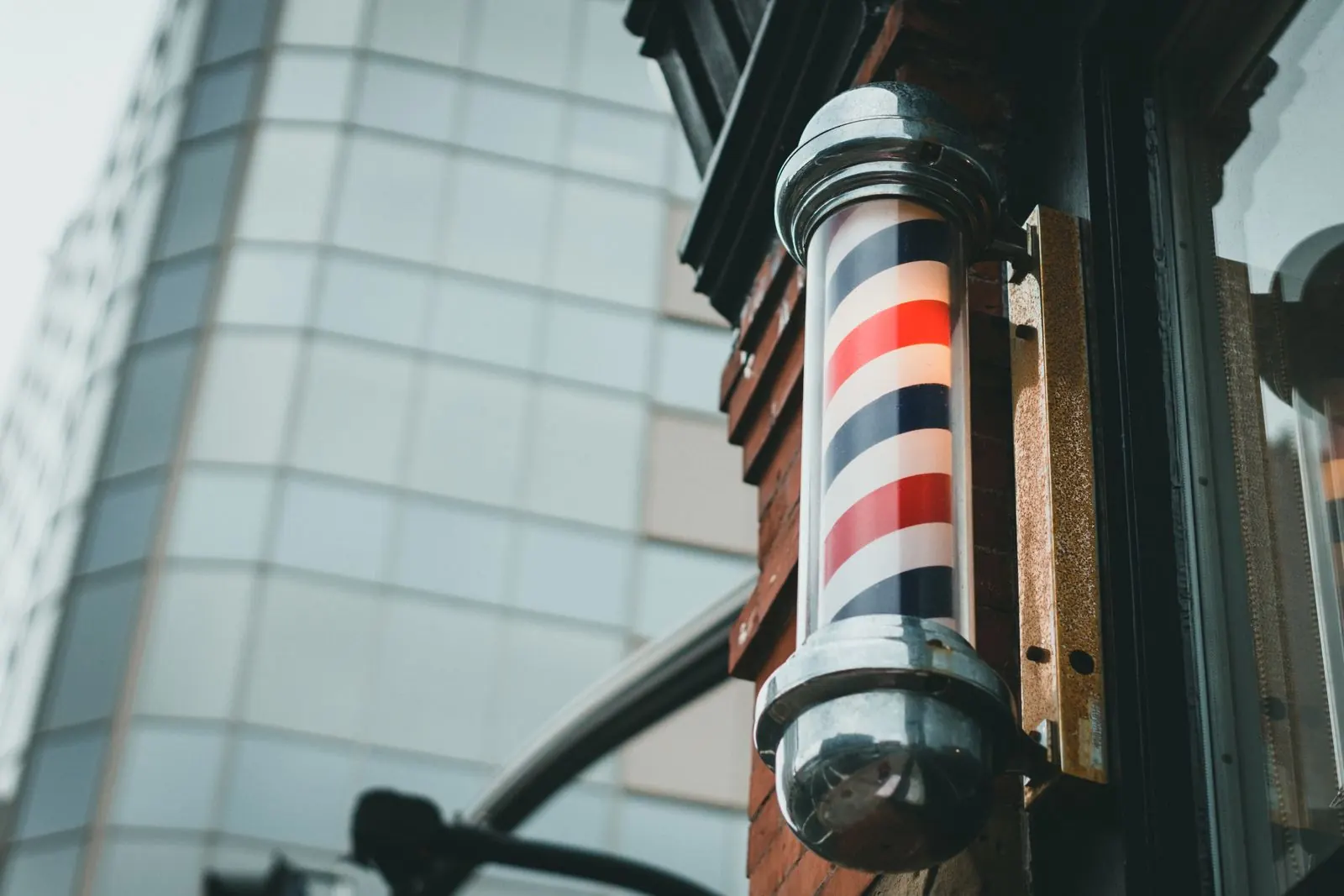 A traditional red, white and blue barber pole outside a shop entrance