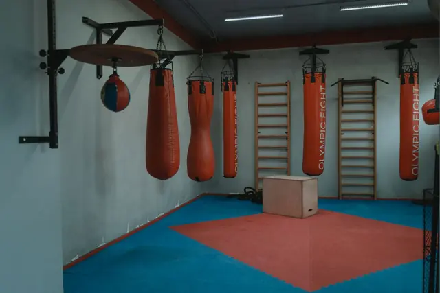 Heavy punch bags hanging above a padded floor