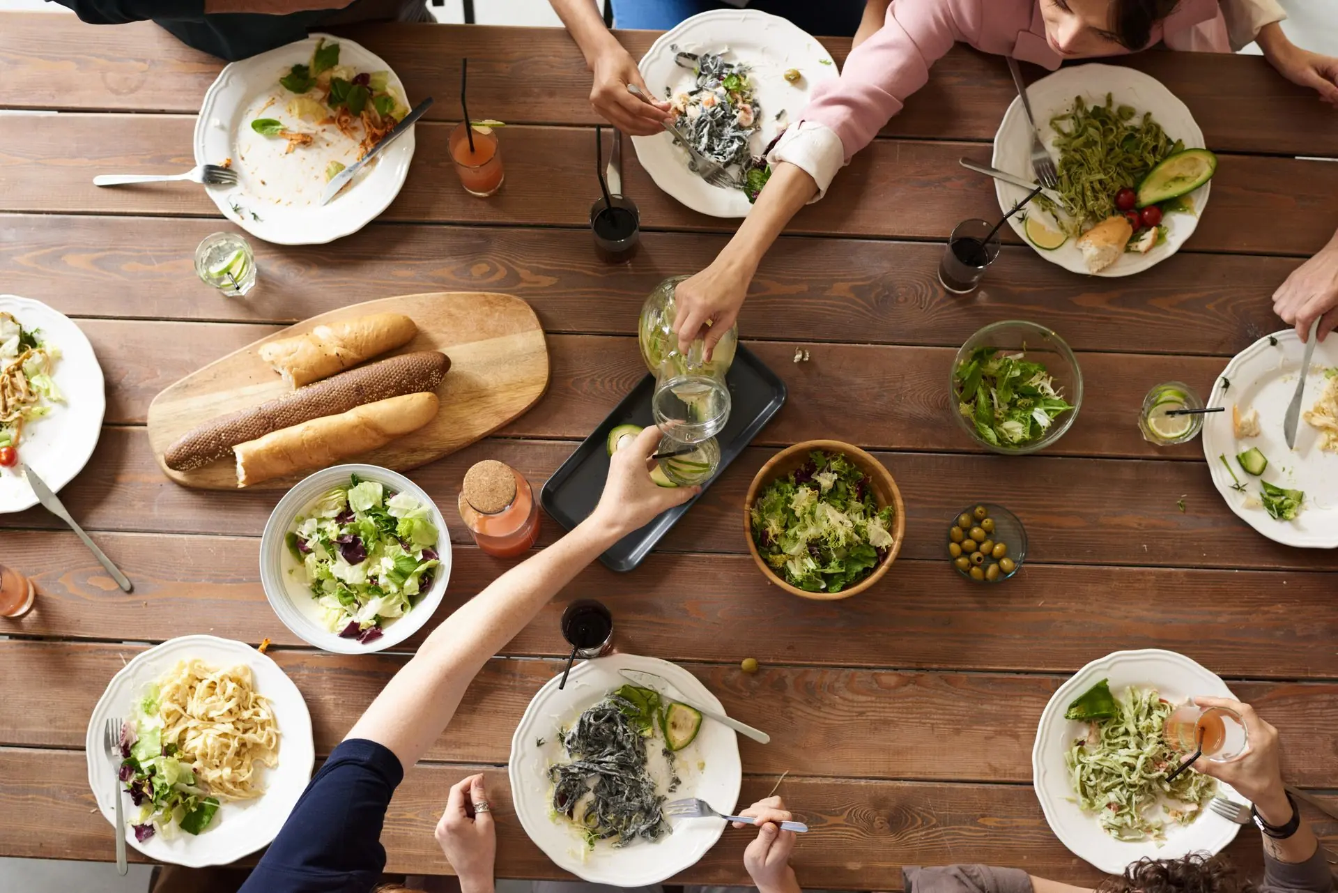 An overhead view of many small dishes shared across a wooden table