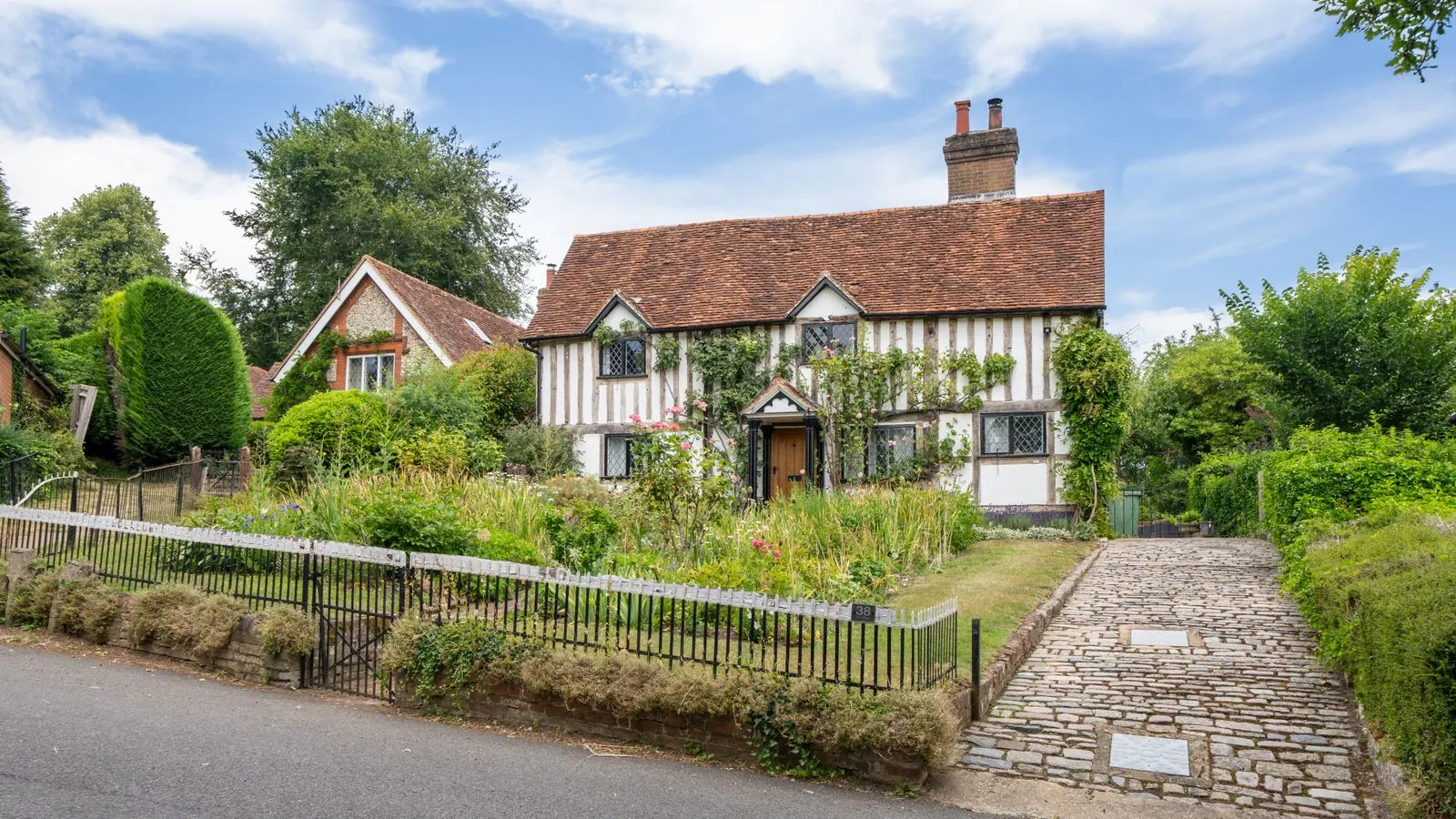 Cream country cottage with a pitched roof and garden path
