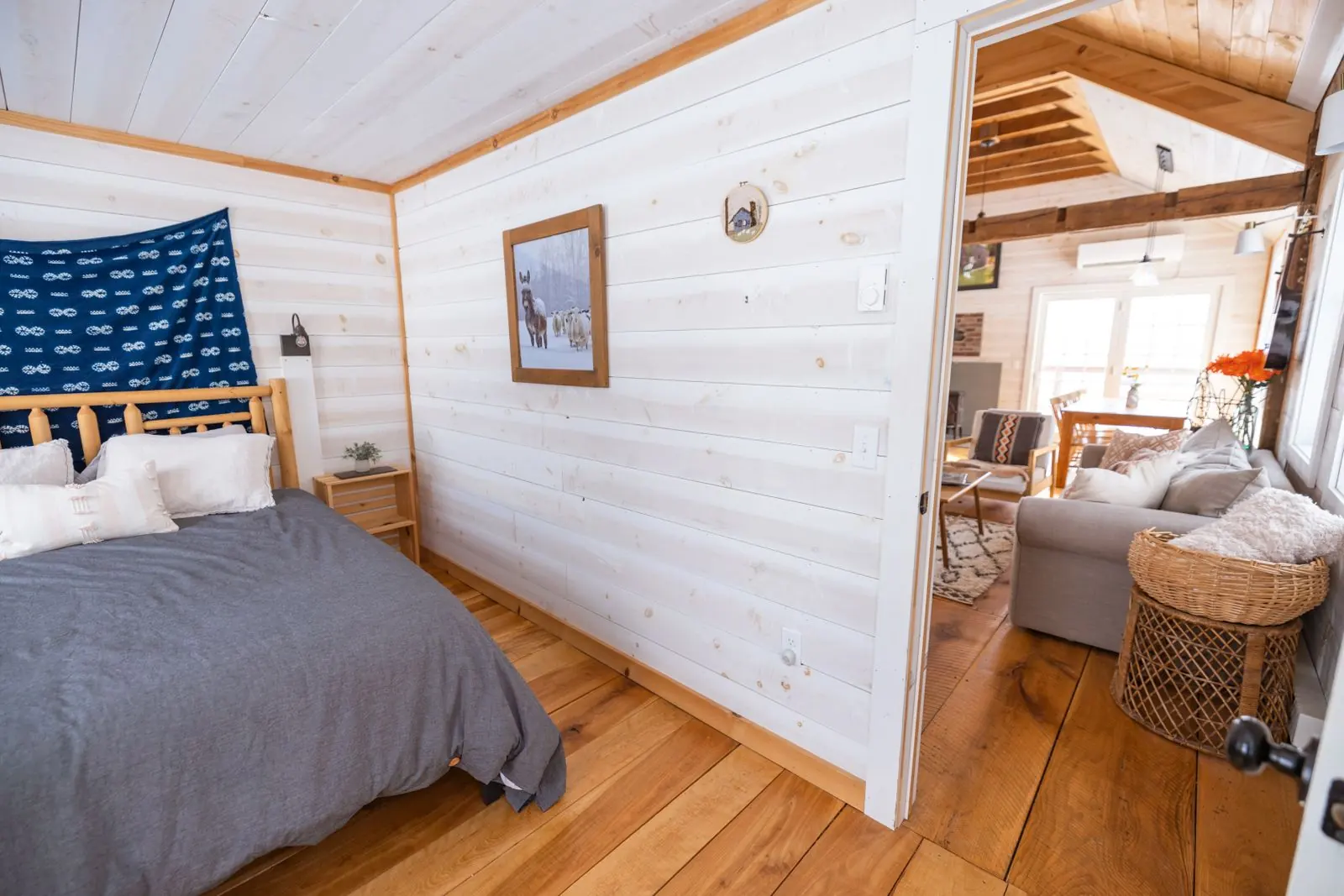 Light cottage bedroom with pale walls and wood flooring