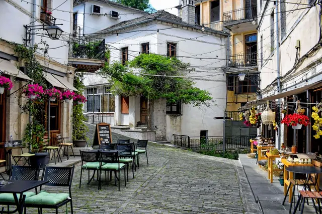 A cobbled lane lined with café tables, flower boxes and whitewashed buildings