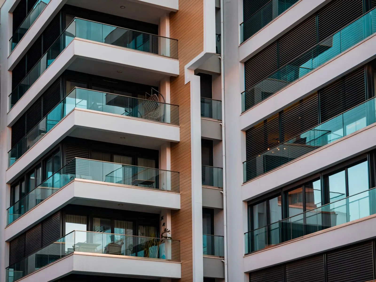 Modern residential building with deep balconies and warm facade accents