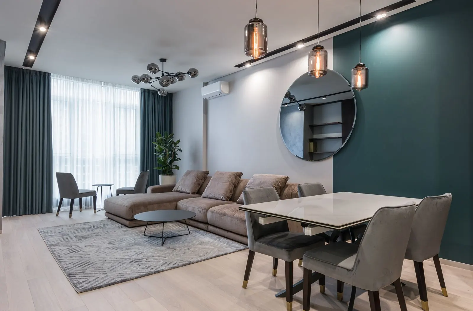 Contemporary apartment living room with a grey sofa and dark green wall
