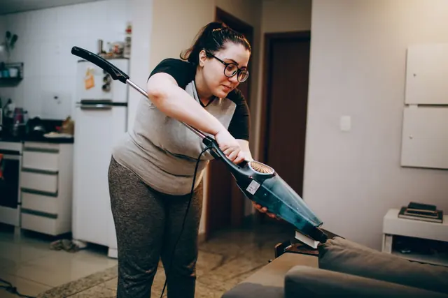 A person vacuuming a living room rug