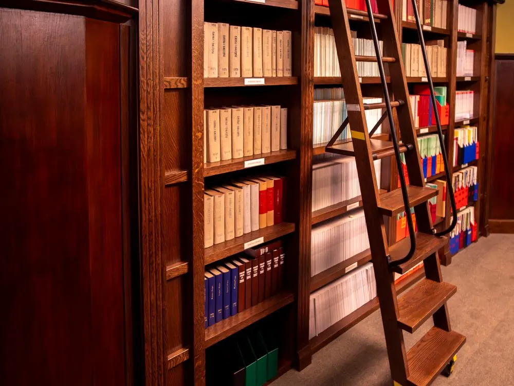 Law library shelves with wood finishes and a rolling ladder