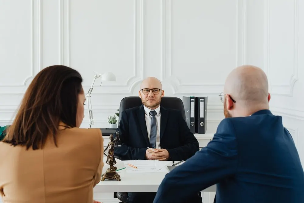 Clients seated in a legal consultation in a light office