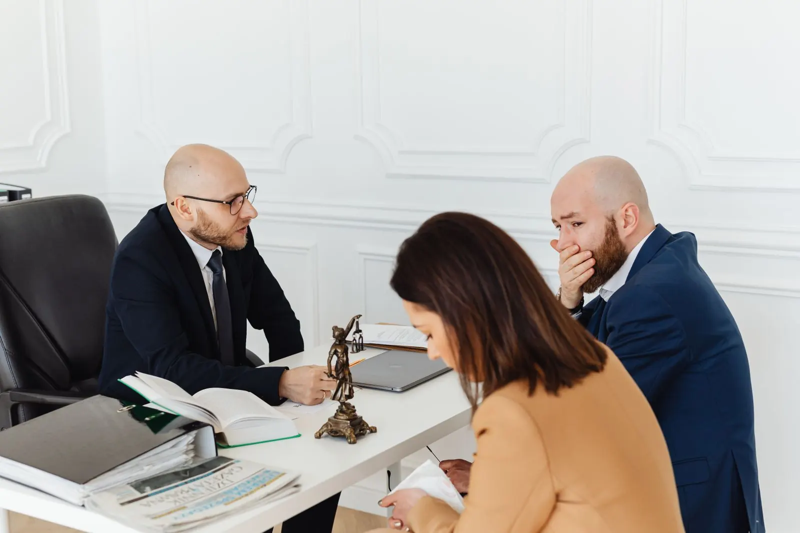 Clients in a consultation around a lawyer’s office desk