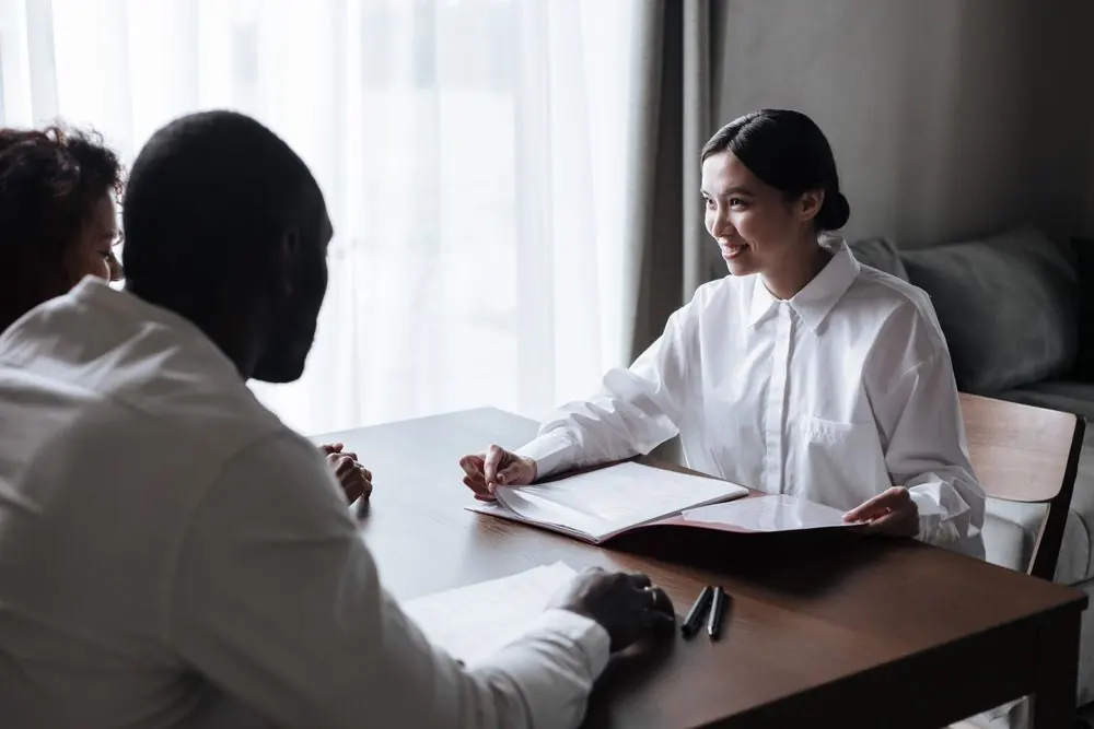 Two people discussing paperwork in a home setting