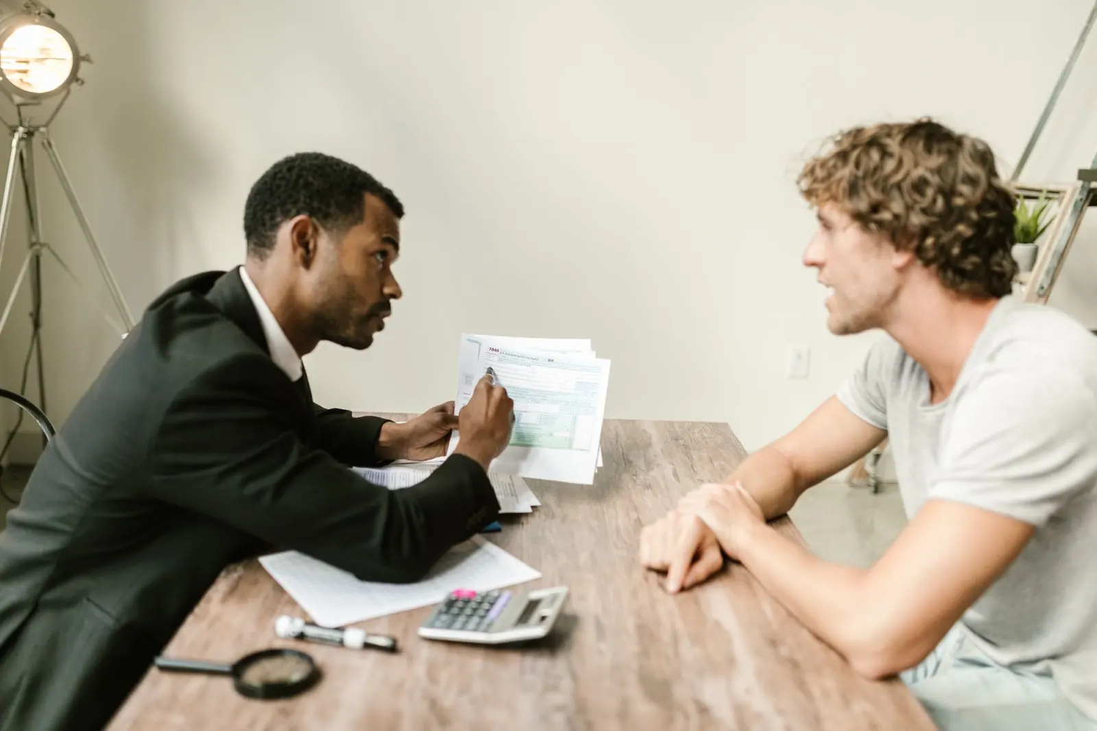 Adviser and visitor discussing documents across a desk