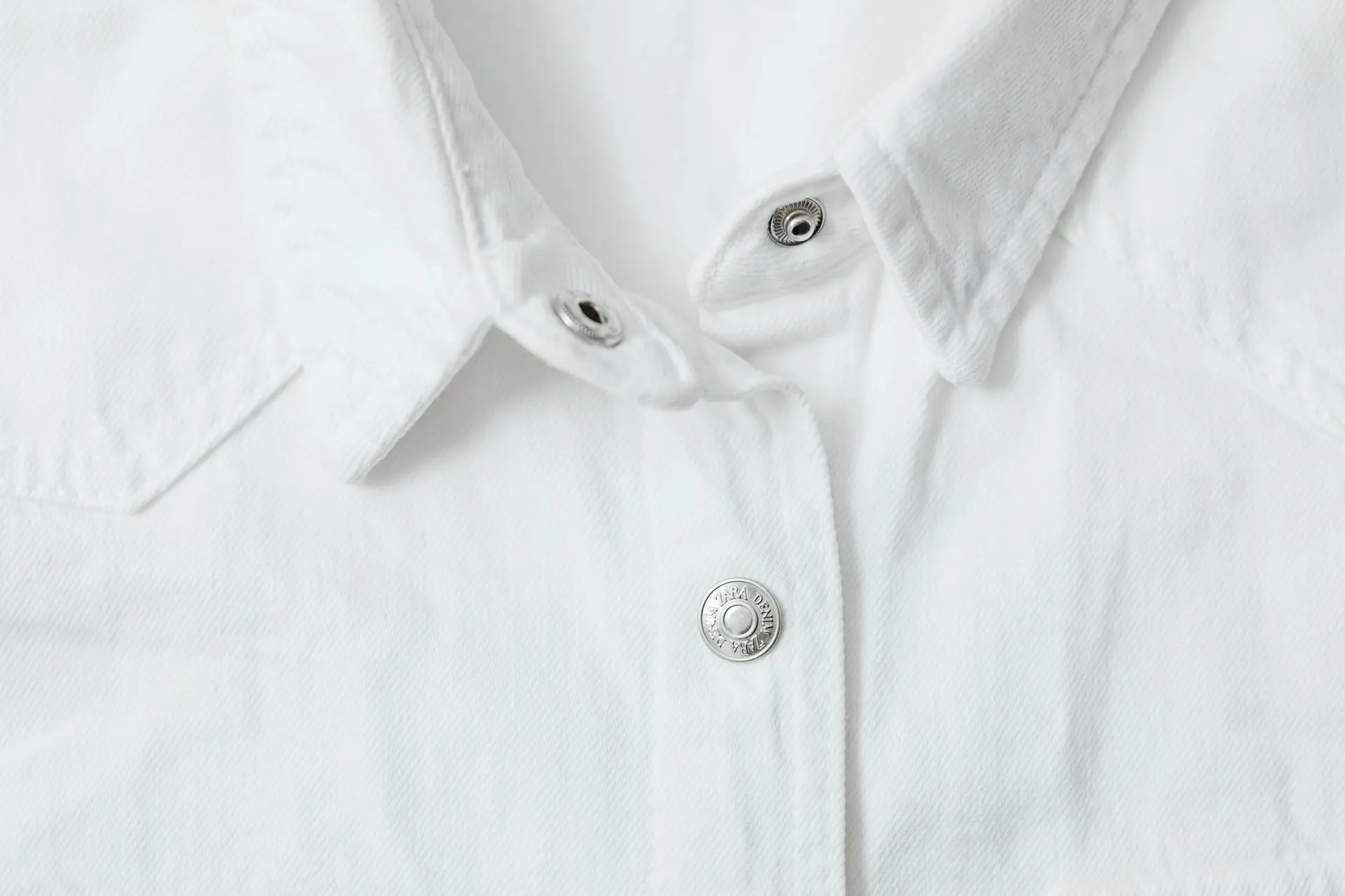 Close-up of a crisp white shirt collar and buttons
